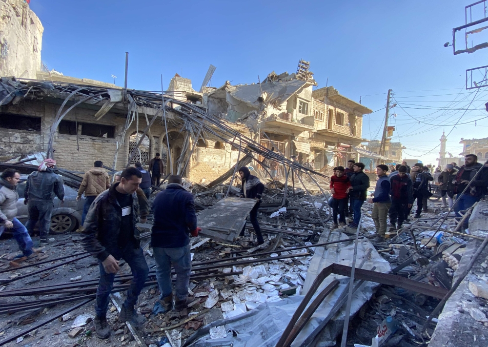 Syrians gather amidst the rubble following regime airstrikes on a market in the town of Binnish in Syria’s northwestern province of Idlib on January 11, 2020. (AFP / Omar HAJ KADOUR)
