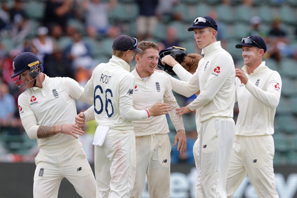 England's Dominic Bess (C) celebrates with teammates after the dismissal of South Africa's Rassie van der Dussen during the third day of the third Test cricket match between South Africa and England at the St George's Park Cricket Ground in Port Elizabeth
