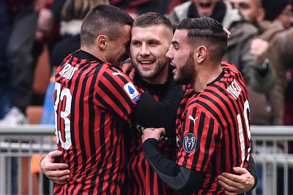 AC Milan's Croatian forward Ante Rebic (C) celebrates with AC Milan's Bosnian midfielder Rade Krunic (L) and AC Milan's French defender Theo Hernandez after scoring a last second winnin goal during the Italian Serie A football match AC Milan vs Udinese on