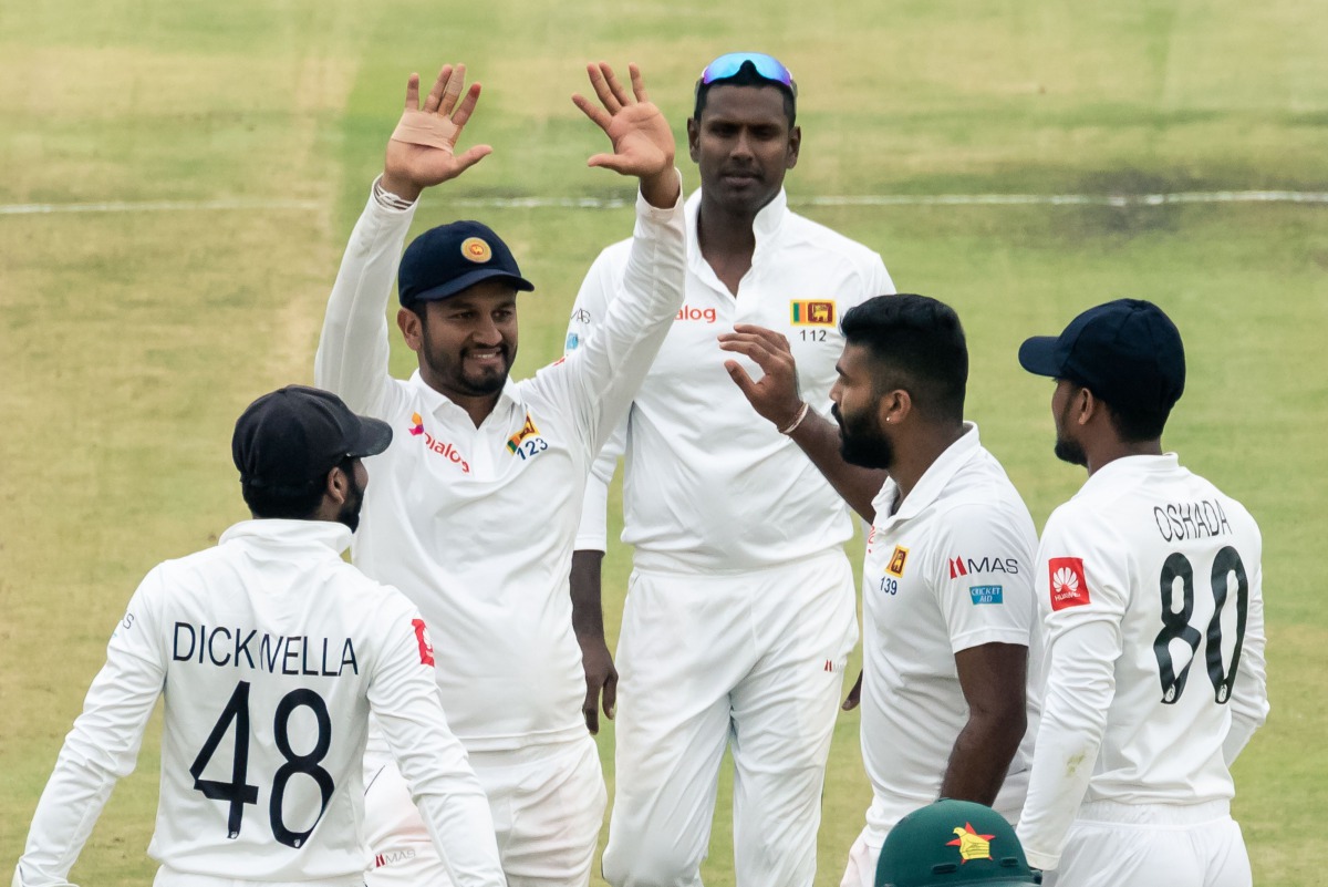 Sri Lanka's captain Dimuth Karunaratne (2ndL) celebrates with teammates after the dismissal of Zimbabwe's Kevin Kasuza during the first day of the first Test cricket match between Zimbabwe and Sri Lanka at the Harare Sports Club in Harare on January 19, 2
