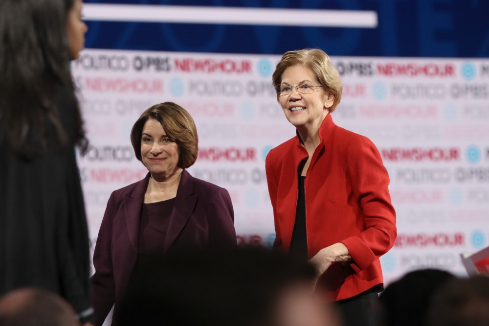 (FILES) In this file photo taken on December 19, 2019, Democratic presidential candidate Senator Elizabeth Warren (D-MA) (R) and Senator Amy Klobuchar (D-MN)) walk on the stage after the Democratic presidential primary debate at Loyola Marymount Universit