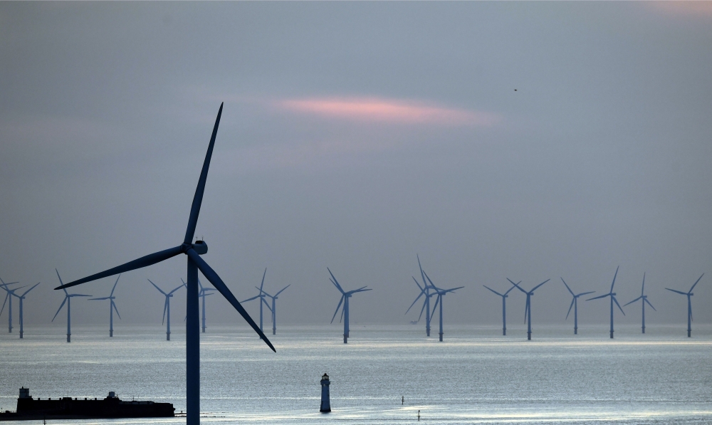 New Brighton lighthouse at the mouth of the river Mersey, in north-west England on May 14 2019 with the Burbo Bank Offshore Wind Farm visible on the horizon, on May 14, 2019. AFP / Paul Ellis 