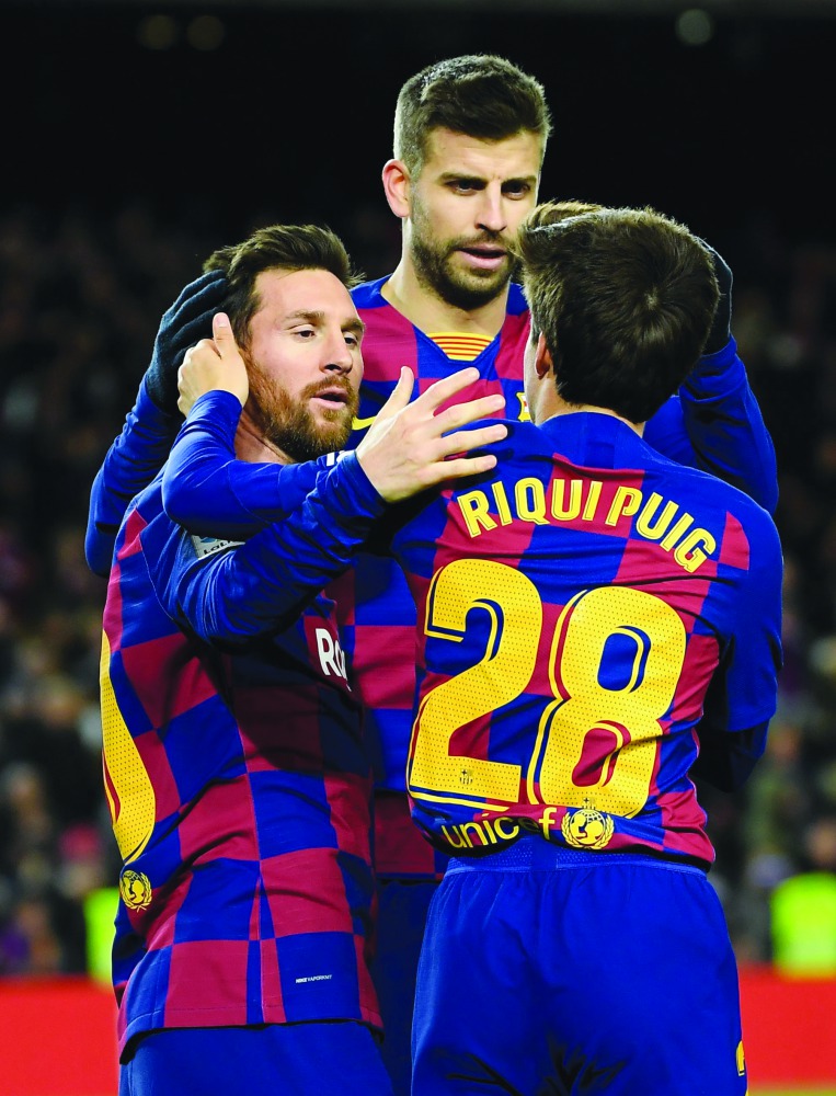 Barcelona's Argentine forward Lionel Messi (L) is congratulated by Barcelona's Spanish midfielder Riqui Puig after scoring the opening goal during the Spanish league football match between FC Barcelona and Granada FC at the Camp Nou stadium in Barcelona o