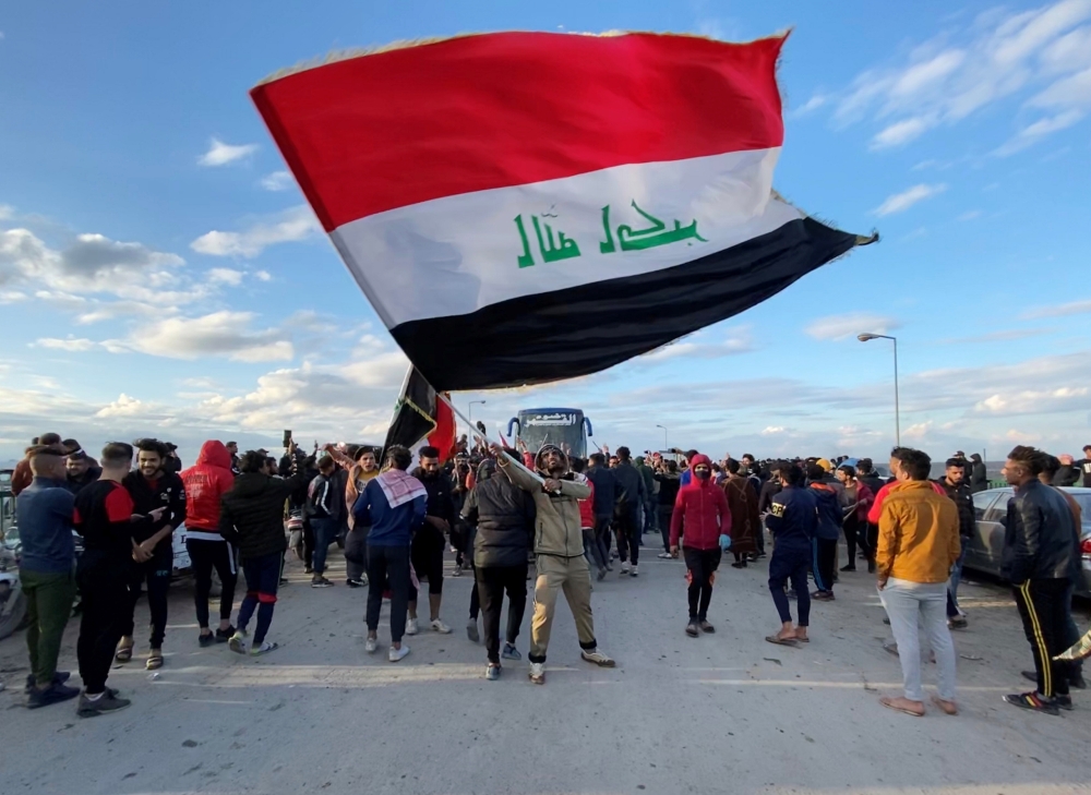 A demonstrator carries an Iraqi flag during ongoing anti-government protests in Nassiriya, Iraq January 22, 2020. REUTERS/Ahmed Dhahi 