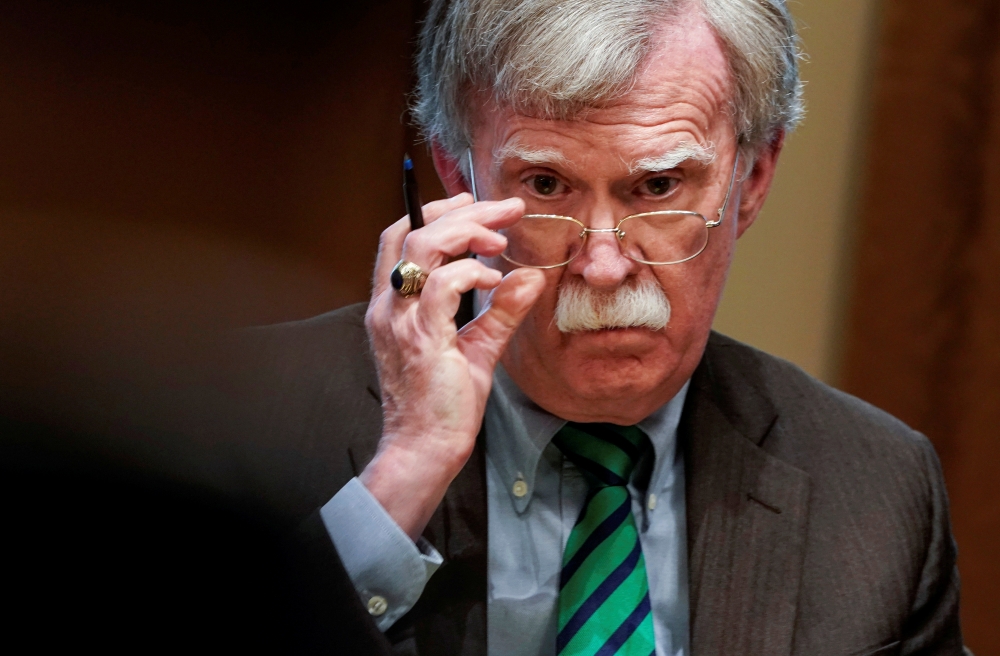 John Bolton adjusts his glasses as Donald Trump speaks while meeting with NATO Secretary General Jens Stoltenberg in the Oval Office, April 2, 2019. Reuters / Joshua Roberts