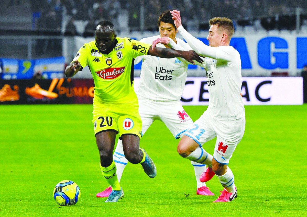 Angers forward Sada Thioub (left) vies with Marseille defender Valentin Rongier during the French L1 football match  at the Velodrome Stadium in Marseille, southern France on Saturday.