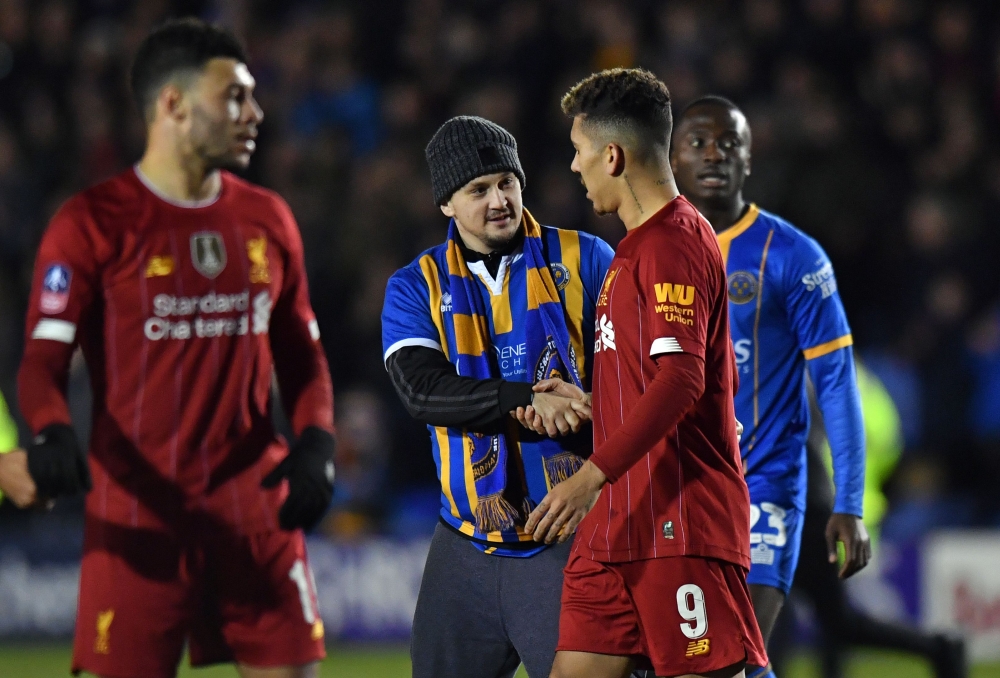 A Shrewsbury fan shakes hands with Liverpool's Brazilian midfielder Roberto Firmino after the final whistle in the English FA Cup fourth round football match between Shrewsbury Town and Liverpool at the Montgomery Waters Meadow Stadium in Shrewsbury, nort