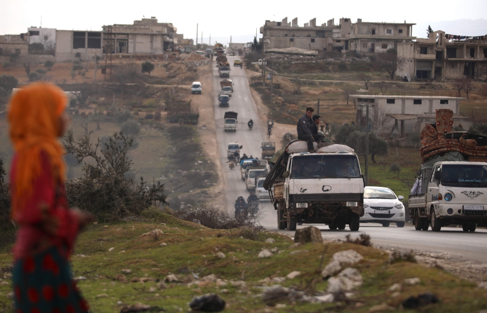 Syrians drive with their belongings through the town of Ariha in the northern countryside of Syria's Idlib province on January 27, 2020, as people flee from the south of Idlib amidst an ongoing government forces' offensive. (AFP / AAREF WATAD)