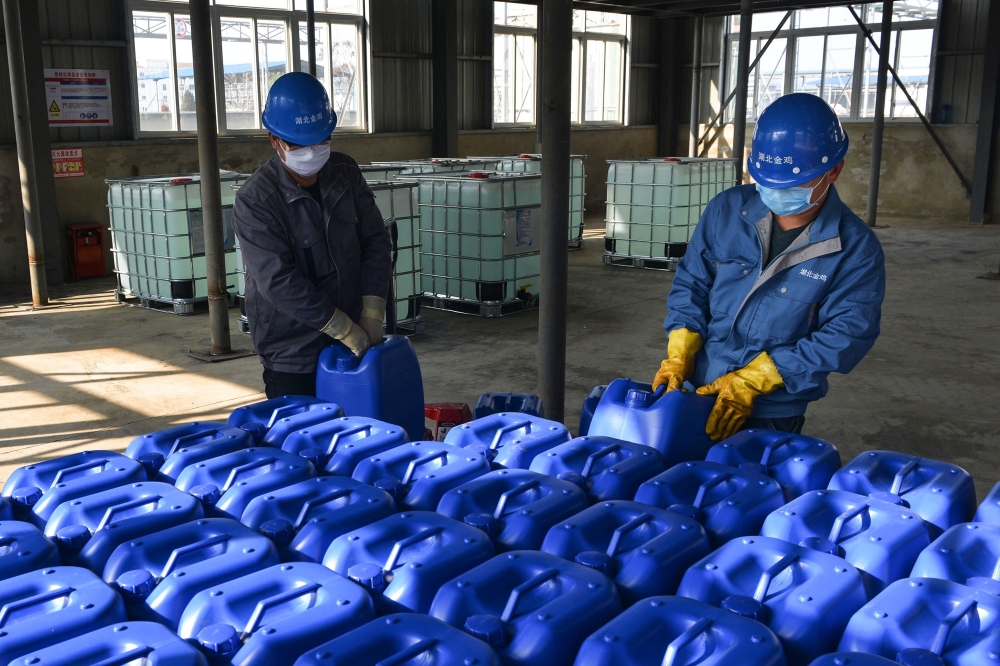 This photo taken on January 30, 2020 shows workers producing disinfectant at a factory in Xiaogan in China's central Hubei province, to support the supply of medical materials during the virus outbreak in Hubei's city of Wuhan. / AFP / STR 