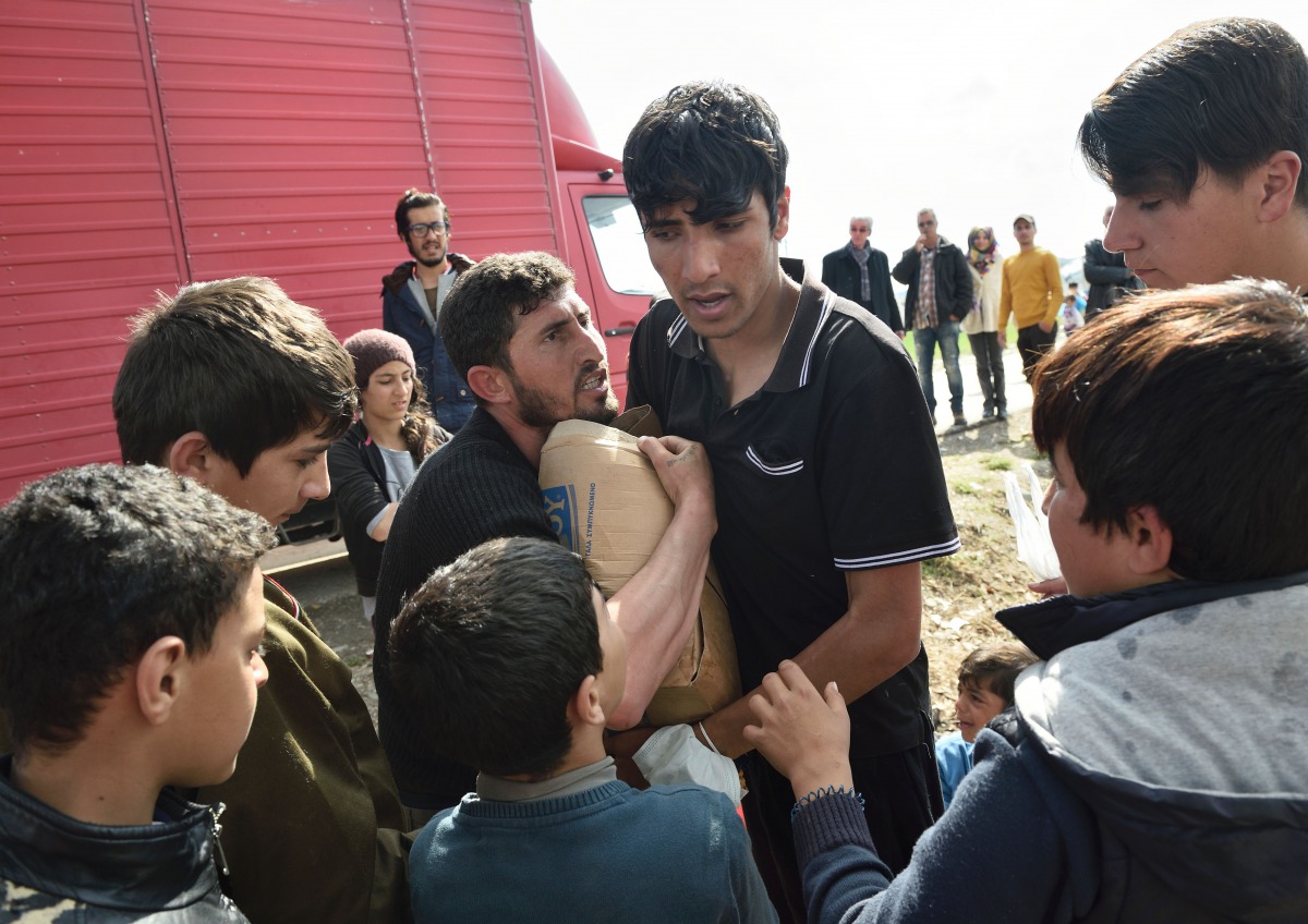 Migrants argue for a box of supplies donated by Greek people on March 11, 2016 in a makeshift camp at the Greek-Macedonian border near the Greek village of Idomeni. AFP / Daniel Mihailescu