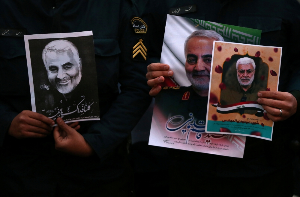 Iranian guards hold a picture of the late Iranian Major-General Qassem Soleimani in Tehran, Iran January 3, 2020. West Asia News Agency / Nazanin Tabatabaee via Reuters