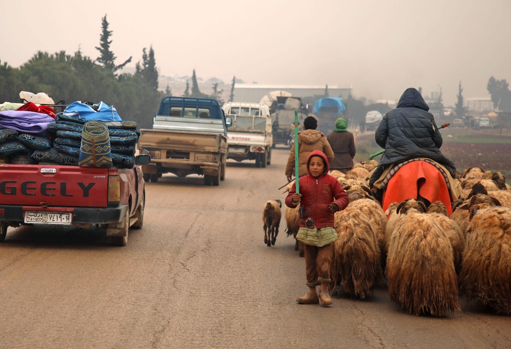Syrians fleeing with their belongings pass through the town of Batabo in the Aleppo province, on February 5, 2020, on their way northwards toward the Turkish border amid an ongoing regime offensive. AFP / Aaref Watad
 