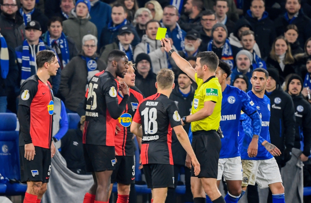 Referee Harm Osmers shows the yellow card to German defender Jordan Torunarigha of Hertha Berlin during the German Cup round of 16 football match on February 4, 2020.  AFP / Ina Fassbender
 