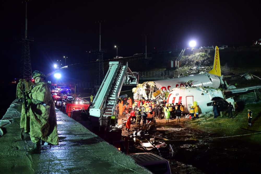 Rescuers work to extract passengers from the crash of a Pegasus Airlines Boeing 737 airplane, after it skidded off the runway upon landing at Sabiha Gokcen airport in Istanbul on February 5, 2020. / AFP / Yasin AKGUL