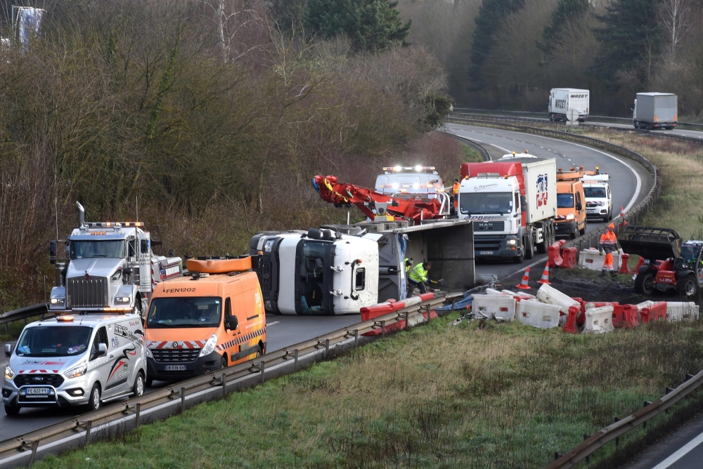 Rescuers work on the A2 motorway in Marly, northern France, after a truck was tipped over in the early morning from strong winds brought by storm Ciara on February 10, 2020. AFP / FRANCOIS LO PRESTI