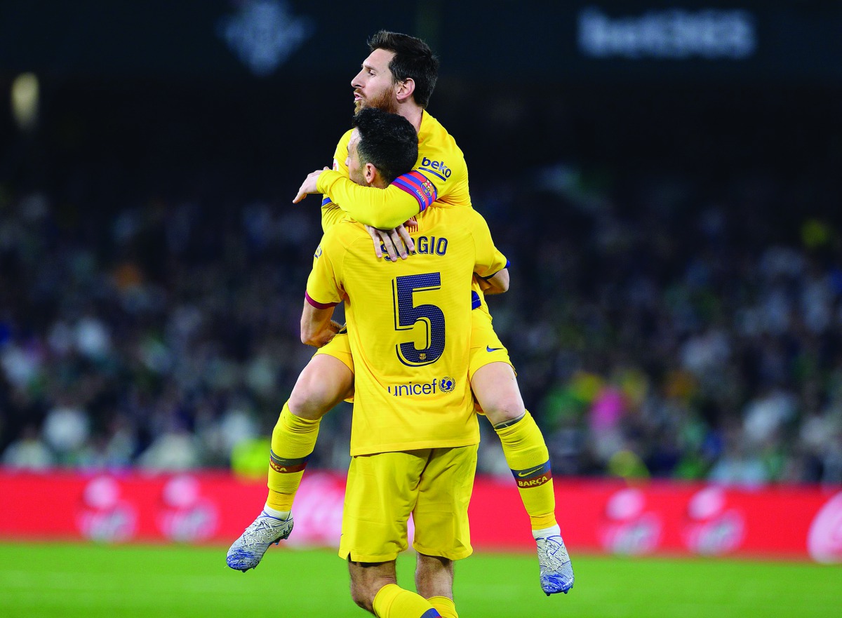 Barcelona's Spanish midfielder Sergio Busquets celebrates his goal with Barcelona's Argentine forward Lionel Messi during the Spanish league football match between Real Betis and FC Barcelona at the Benito Villamarin stadium in Seville on February 9, 2020