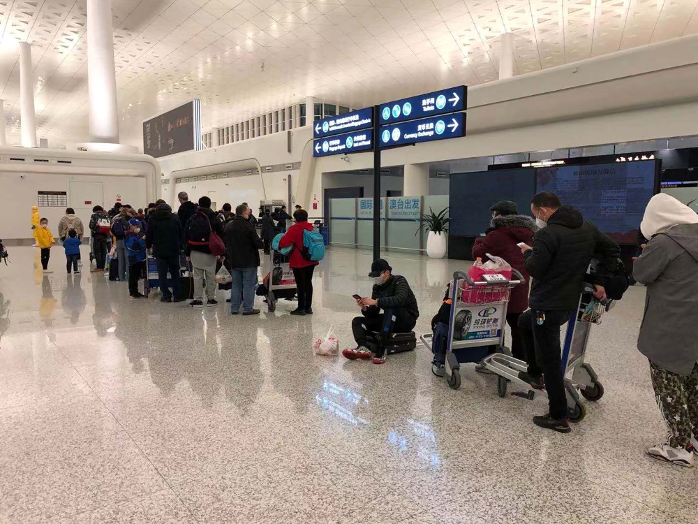 Passengers queue to board a cargo plane, chartered by the U.S. State Department to evacuate Americans and Canadians from China due to the outbreak of novel Coronavirus, at Wuhan Tianhe International Airport in Wuhan, China February 7, 2020. Courtesy of Ed