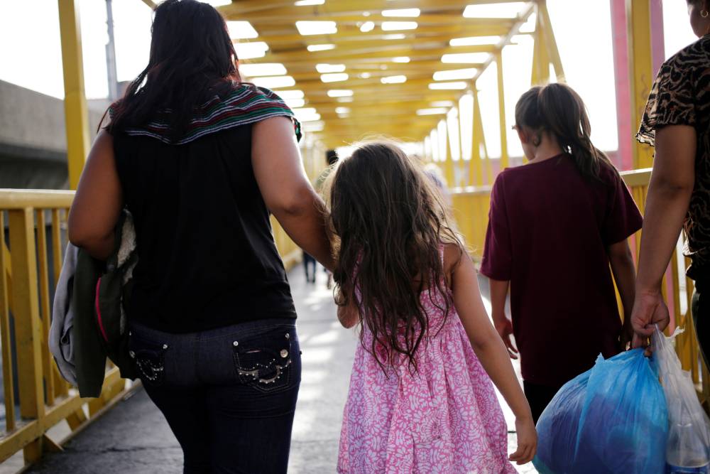 Central American migrants, returned from the U.S. to Nuevo Laredo in Mexico under the Migrant Protection Protocol (MPP) to wait for their court hearing for asylum seekers, are seen walking towards a shelter after arriving to Monterrey, Mexico July 31, 201
