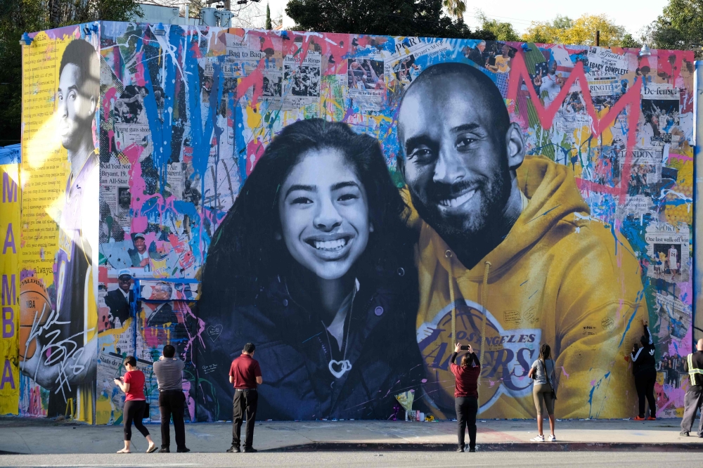  In this file photo taken on January 31, 2020 people take pictures of a mural by French artist Mr. Brainwash of late NBA legend Kobe Bryant and his daughter Gianna in Los Angeles./ AFP / Chris Delmas / 