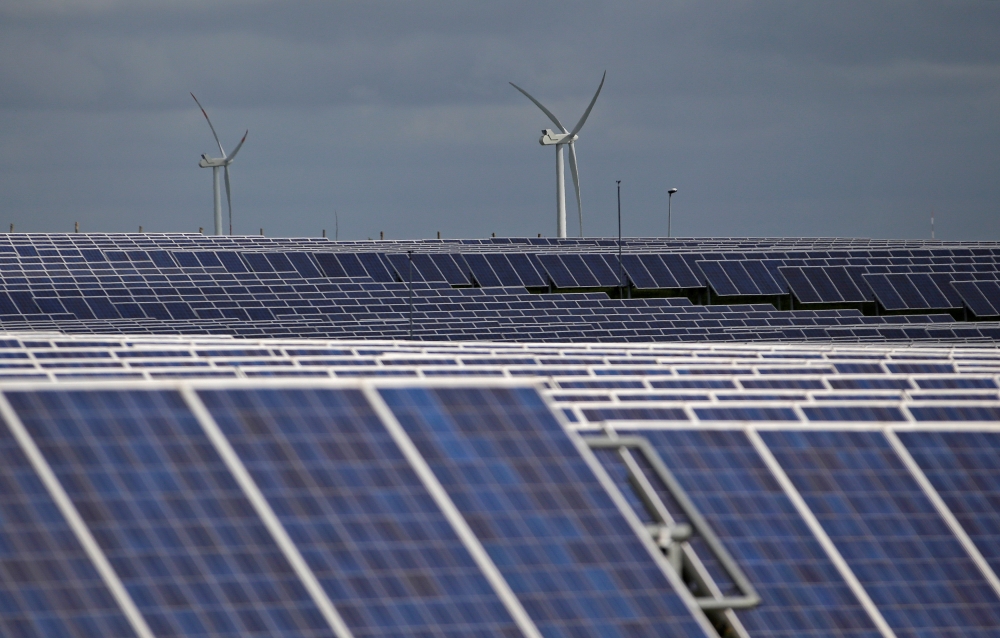 A solar power plant is seen past wind turbines in Canino, central Italy, April 27, 2016. Reuters / Max Rossi