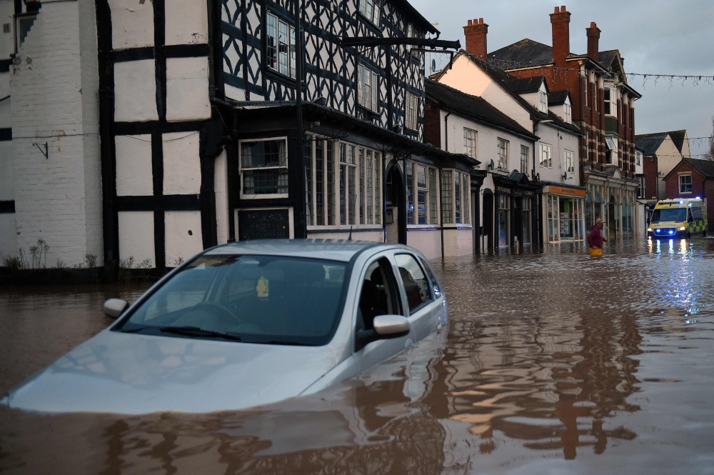 Flood water surrounds abandoned cars left in a flooded street in Tenbury Wells, after the River Teme burst its banks in western England, on February 16, 2020, after Storm Dennis caused flooding across large swathes of Britain. AFP / Oli SCARFF