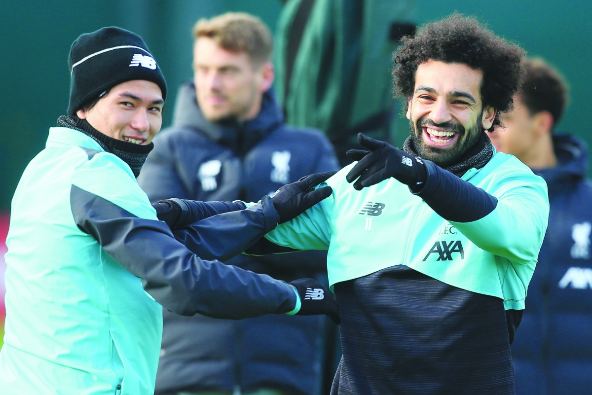 Liverpool's Egyptian midfielder Mohamed Salah (R) jokes with Liverpool's Japanese midfielder Takumi Minamino (L) during a training session at Melwood in Liverpool, north west England on February 17, 2020, on the eve of their UEFA Champions League round of