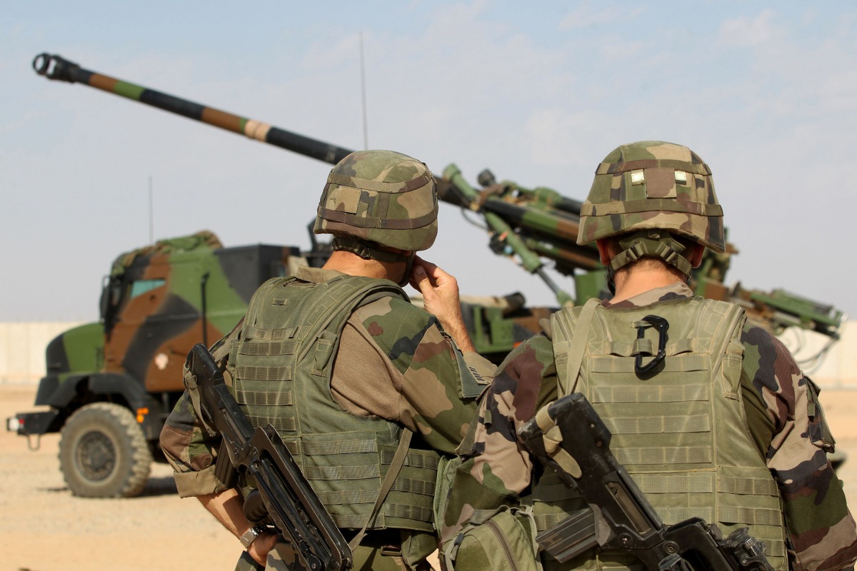 French soldiers stand next to a CAESAR a French self-propelled 155 mm 52-calibre gun-howitzer in the Qayyarah base, south of Mosul on October 31, 2016. AFP
