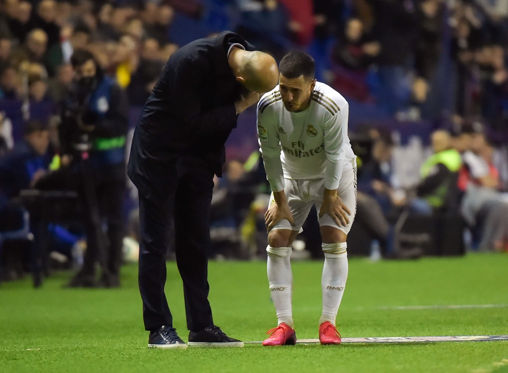 Real Madrid's French coach Zinedine Zidane (L) talks to Real Madrid's Belgian forward Eden Hazard during the Spanish league football match Levante UD against Real Madrid CF at the Ciutat de Valencia stadium in Valencia on February 22, 2020. / AFP / JOSE J