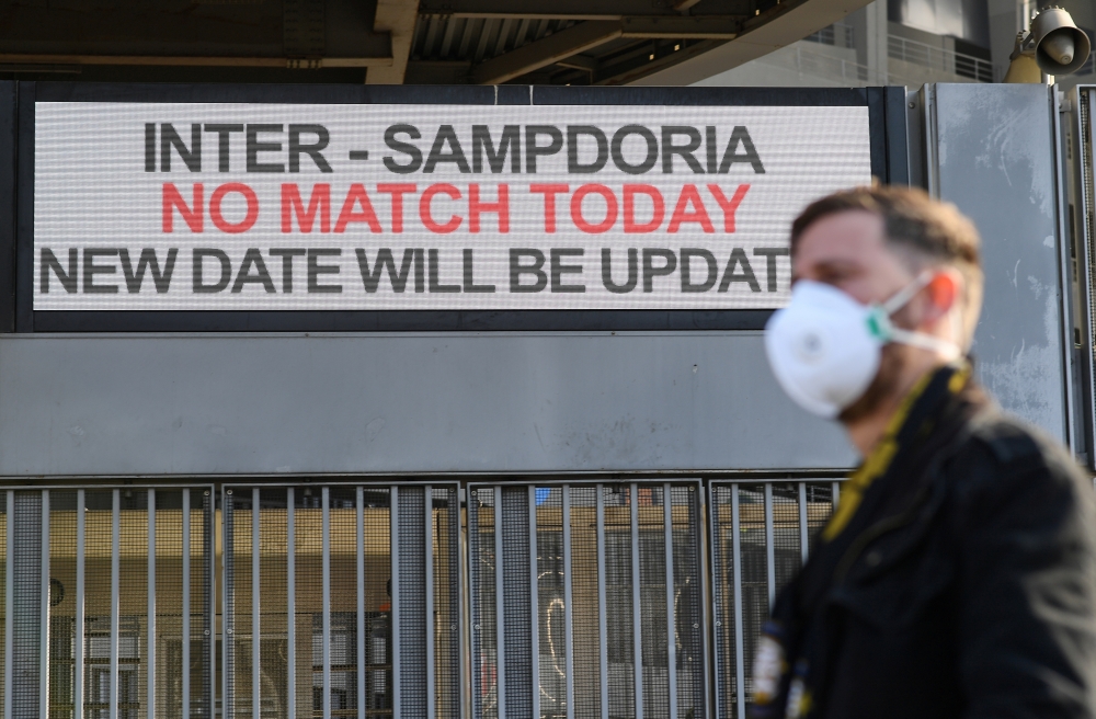 A man wearing a face mask stands outside the San Siro stadium after the Inter Milan v Sampdoria Serie A match was cancelled due to an outbreak of the coronavirus in Lombardy and Veneto, in Milan, Italy, February 23, 2020. Reuters/Daniele Mascolo