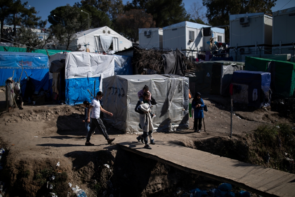 Migrants make their way at a makeshift camp surrounding the Moria migrant camp on the island of Lesbos, Greece, February 18, 2020.  Reuters/Alkis Konstantinidis