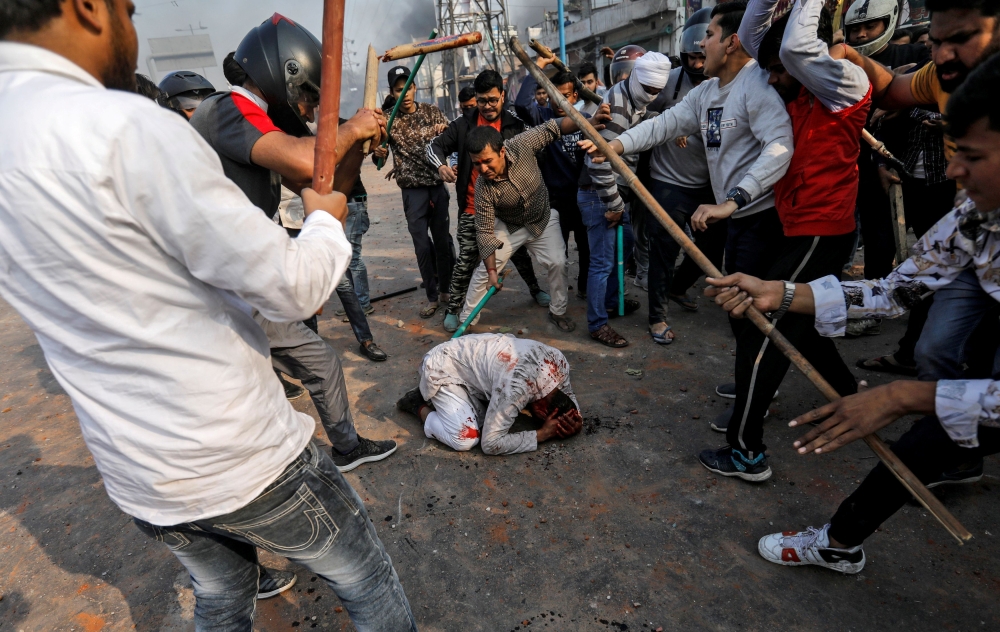 People supporting the new citizenship law beat a Muslim man during a clash with those opposing the law in New Delhi, India, February 24, 2020. Reuters/Danish Siddiqui