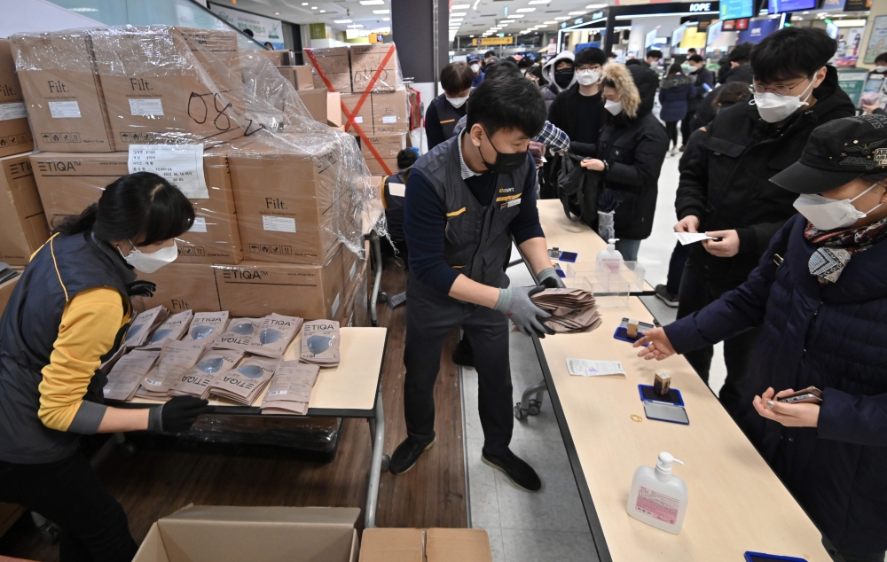 People buy face masks at a retail store in the southeastern city of Daegu on February 25, 2020. AFP / Jung Yeon-je