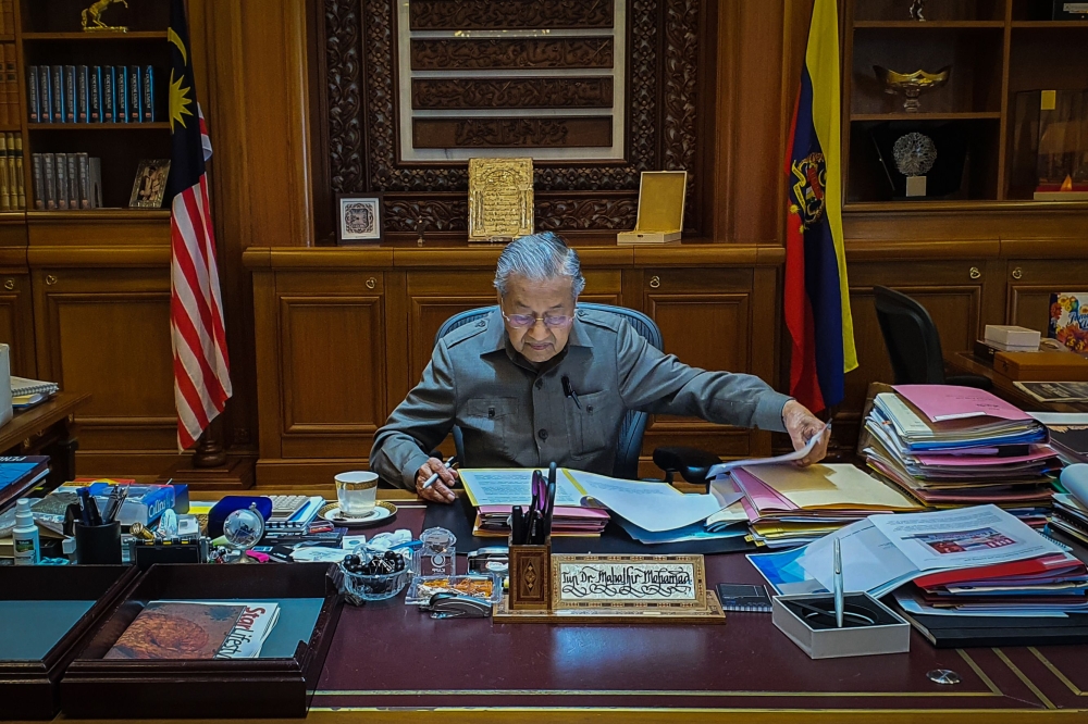This handout photo taken and released on February 25, 2020 by the Prime Minister's Office of Malaysia shows interim prime minister Mahathir Mohamad working in his office in Putrajaya. AFP PHOTO / Prime Minister's Office of Malaysia / Khairul Ariffin