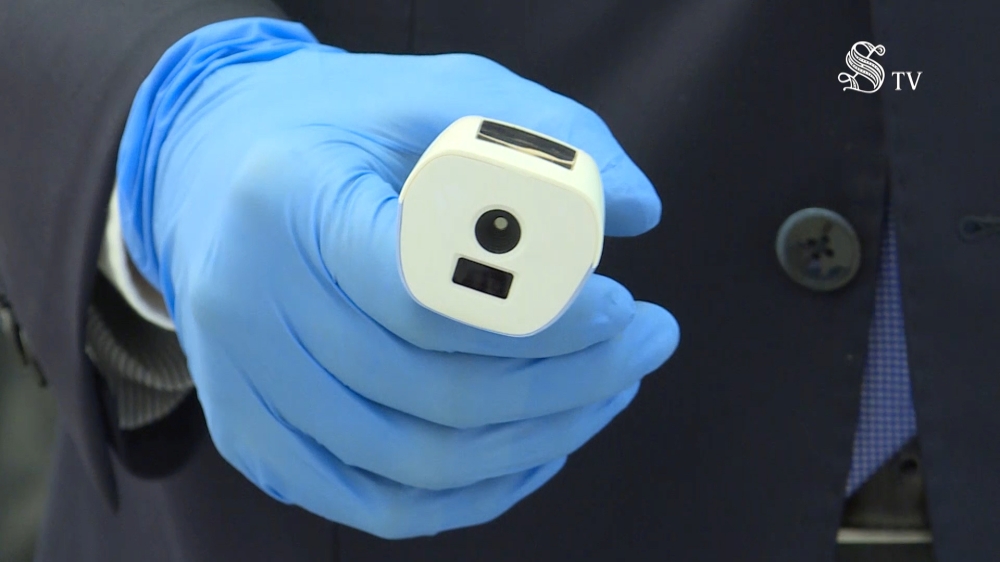 A worker from Italy's Senate wearing protective gloves holds a thermometer to check people arriving at the Piazza Madama Senate building in this still image taken from video in Rome, Italy, February 25, 2020. Senato TV/Handout via REUTERS 
