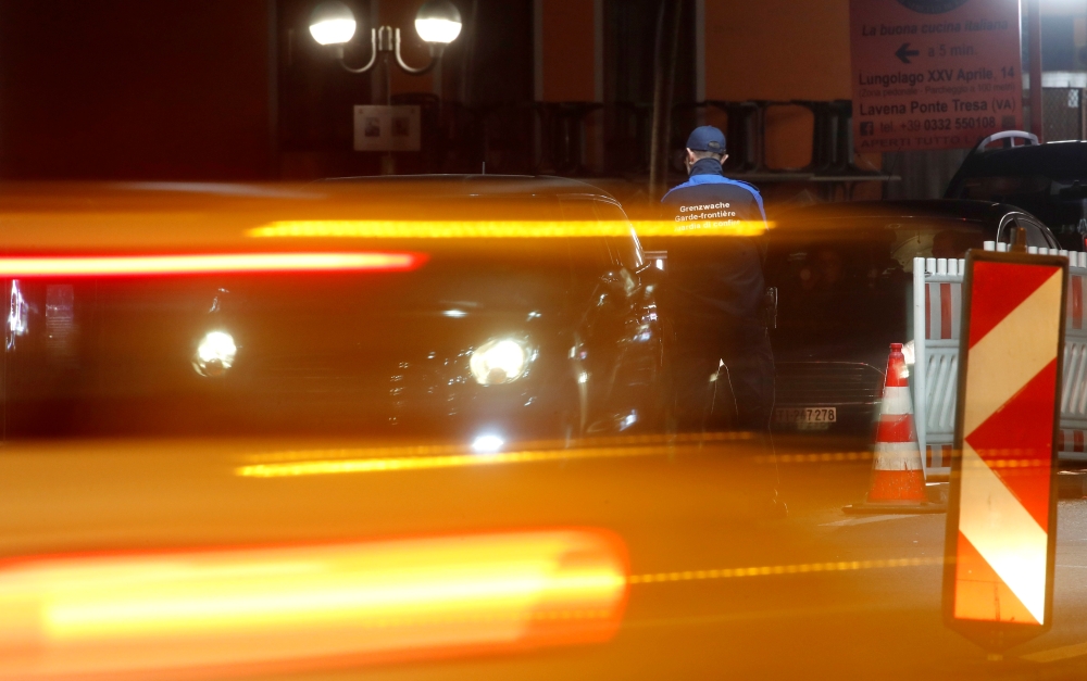 A Swiss border guard checks a car at the Swiss-Italian border in Ponte Tresa, Switzerland February 24, 2020. Reuters/Arnd Wiegmann
 