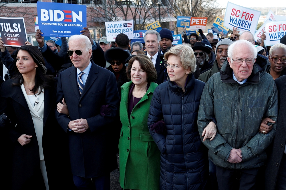 Tulsi Gabbard, Joe Biden, Amy Klobuchar, Elizabeth Warren and Bernie Sanders, walk arm-in-arm with during the MLK Day Parade in Columbia, January 20, 2020. Reuters / Randall Hill