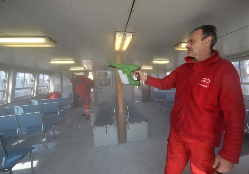 Members of sanitation services sanitise a vaporetto public waterbus in Venice on February 26, 2020, after the COVID-19 outbreak has spread to northern Italy.  AFP / ANDREA PATTARO