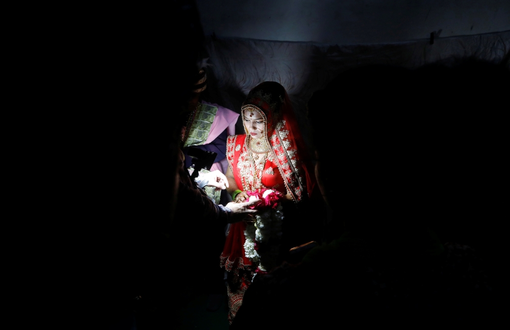 Savitri Prasad, a 23-year-old bride, takes her wedding vows inside her parents' house in a riot affected area following clashes between people demonstrating for and against a new citizenship law in New Delhi, India, February 26, 2020. REUTERS/Adnan Abidi