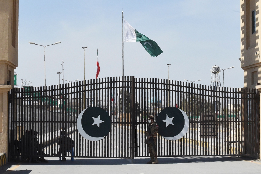 Pakistani soldiers wearing facemasks stand guard at the closed Pakistan-Iran border in Taftan on February 25, 2020 as fears over the spread of the COVID-19 coronavirus escalate following an outbreak in neighbouring Iran. / AFP / Banaras KHAN 