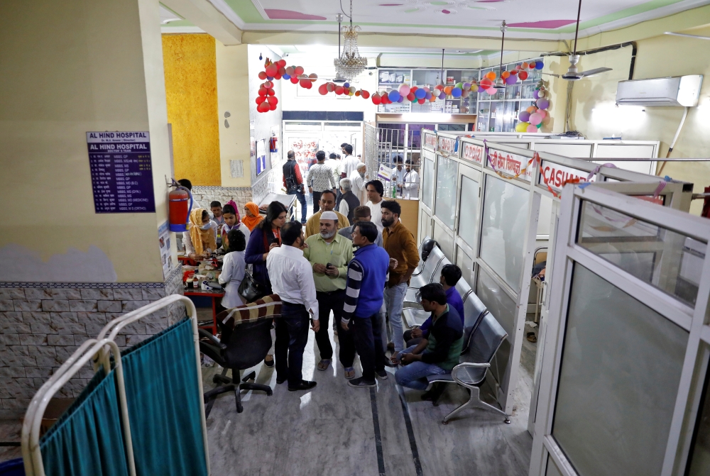 Staff members and volunteers speak in a lobby of Al-Hind hospital, where victims are treated and many have taken shelter after they fled their homes following clashes between people demonstrating for and against a new citizenship law in a riot affected ar