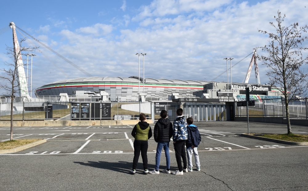 Boys look at the Allianz Stadium, after five Serie A matches were postponed because of the ongoing coronavirus crisis, in Turin, Italy, February 29, 2020. REUTERS/Massimo Pinca