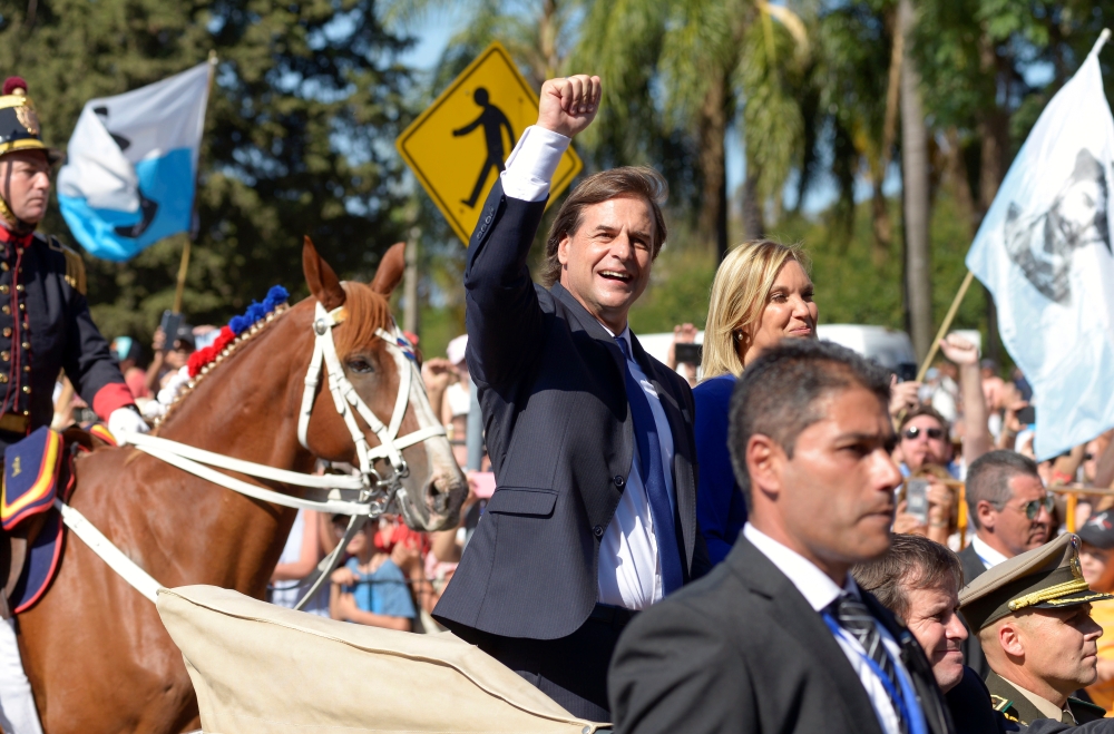 Uruguay's new President Luis Lacalle Pou gestures next to new Vice President Beatriz Argimon as they are driven around the Parliament after being sworn into office, in Montevideo, Uruguay March 1, 2020. Reuters/Andres Cuenca Olaondo