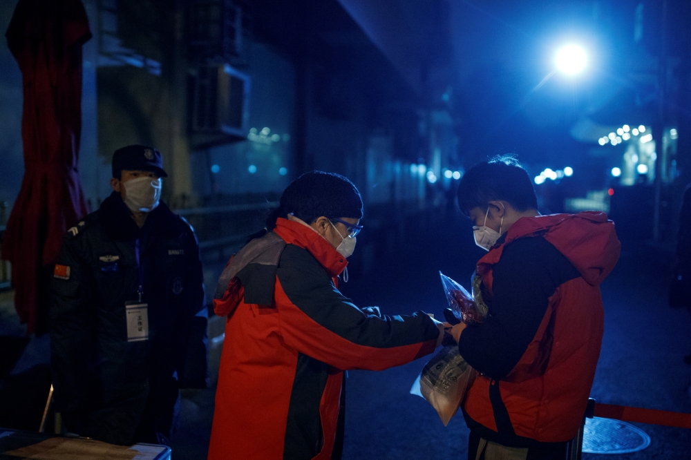  A guard checks the temperature of a man at a checkpoint to a hutong neighbourhood in Beijing as the country is hit by an outbreak of the novel coronavirus, China, February 26, 2020. REUTERS/Thomas Peter 