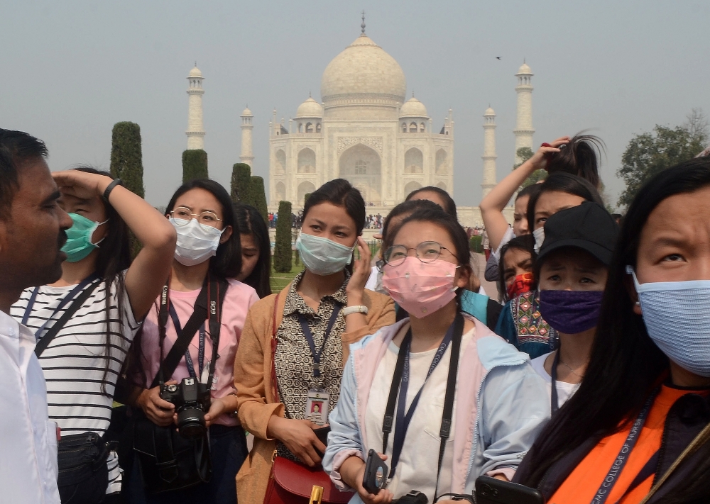 Tourists wearing protective masks are pictured at the historic Taj Mahal in Agra, India, March 3, 2020. REUTERS/Stringer 