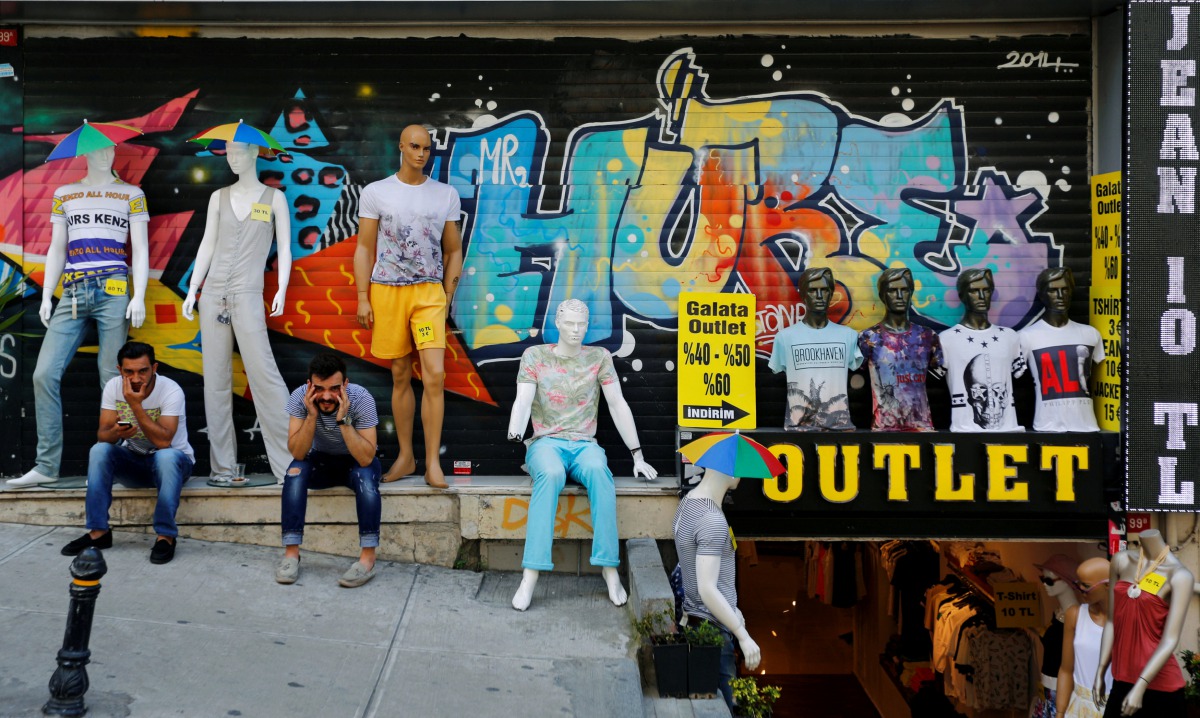 FILE PHOTO: Men sit outside a discount clothing retail store in Istanbul, Turkey, July 13, 2016. Reuters / Murad Sezer