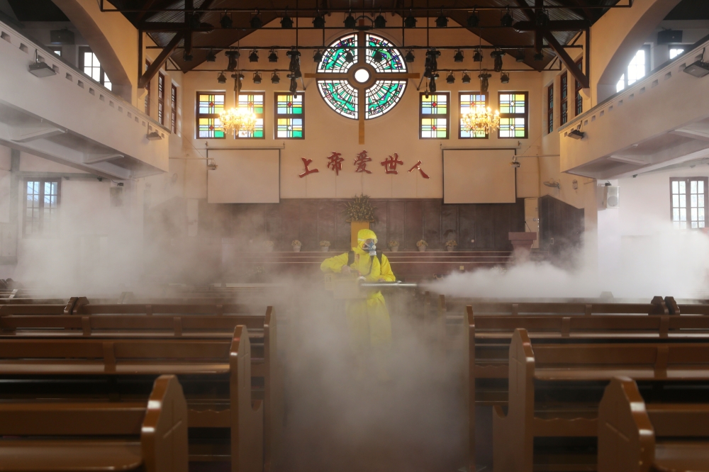 A worker disinfects the Hankou Salvation Church in Wuhan, in China's central Hubei province on March 6, 2020. / AFP / STR
