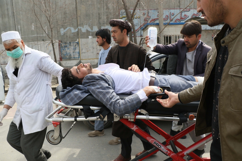 An injured man is brought on a stretcher to an ambulance following a gun attack during an event to mark the 25th anniversary of death of Shiite leader Abdul Ali Mazari, In Kabul on March 6, 2020. AFP / STR