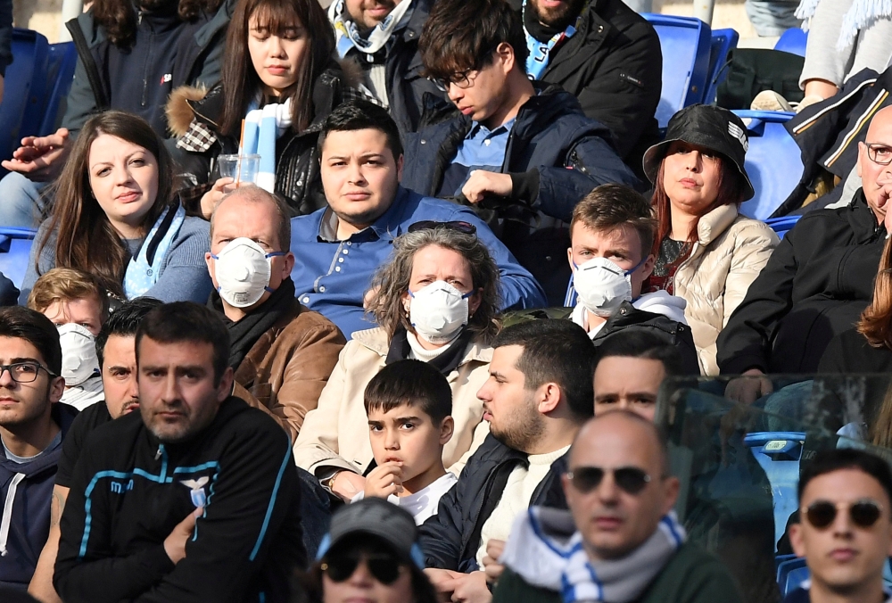 FILE PHOTO: General view of fans wearing face masks in the stands due to the recent outbreak of coronavirus REUTERS/Alberto Lingria
