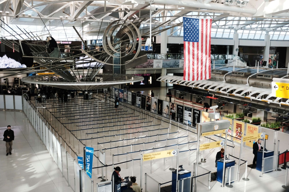 People walk through a sparse international departure terminal at John F. Kennedy Airport (JFK) as concern over the coronavirus grows on March 7, 2020 in New York City.  Spencer Platt/Getty Images/AFP
 