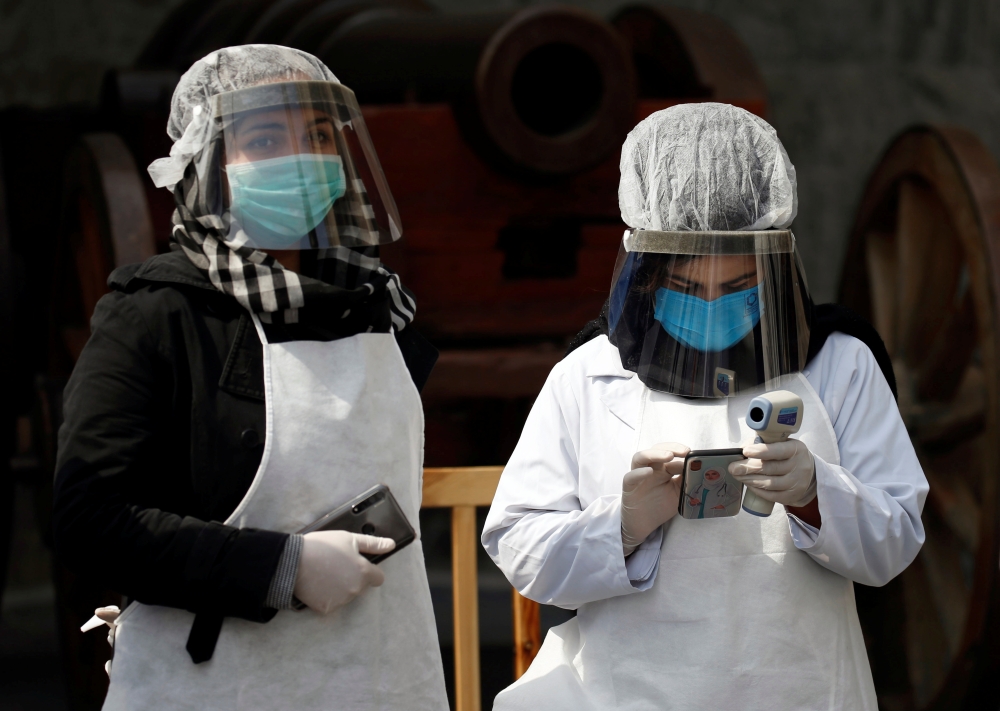 Afghan health workers in protective gears wait to check people during Afghanistan's President Ashraf Ghani inauguration as president, at the Presidential Palace in Kabul, Afghanistan March 9, 2020. Reuters/Mohammad Ismail